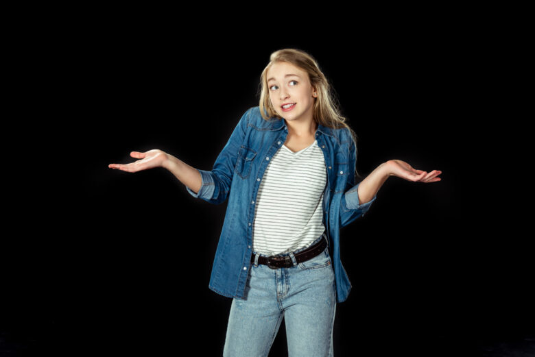 Academy of Acting teen girl shrugging shoulders isolated on black