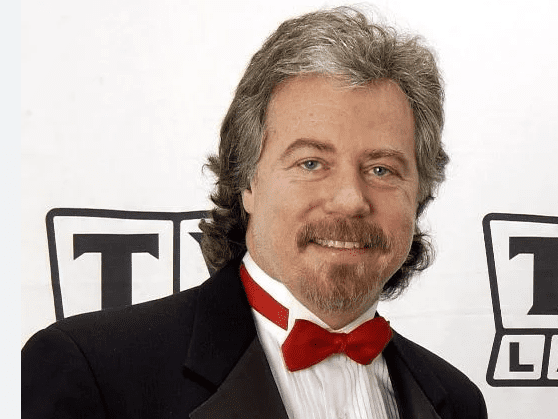 A man with long hair and beard wearing a tuxedo.